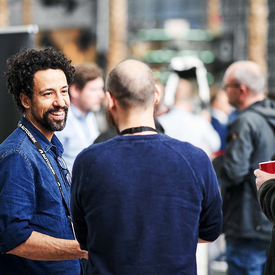 Two men are engrossed in conversation at a trade fair.