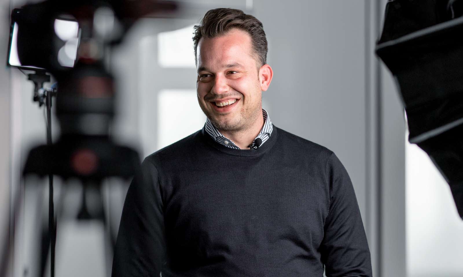 Nicolas Mertzios standing in a photo studio and smiling