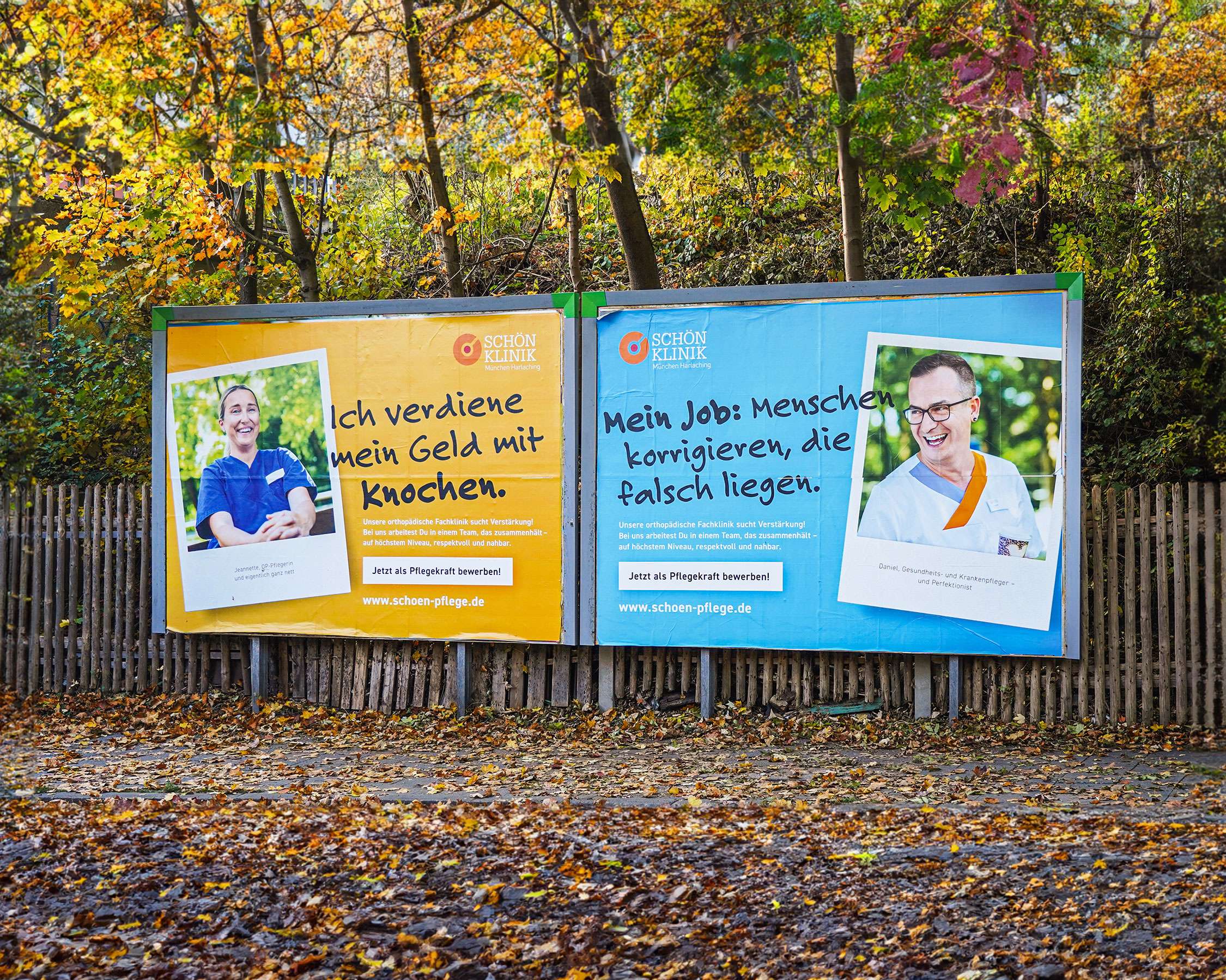 Zwei nebeneinander stehende Straßenplakate in orange/gelb und himmelblau aus der Personalkampagne der Schön Klinik in herbstlicher Kulisse
